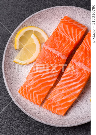 Fresh raw salmon steak with spices and herbs prepared for grilled baking Fresh raw salmon steak with spices and herbs prepared for grilled baking 113310790