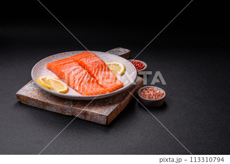Fresh raw salmon steak with spices and herbs prepared for grilled baking 113310794