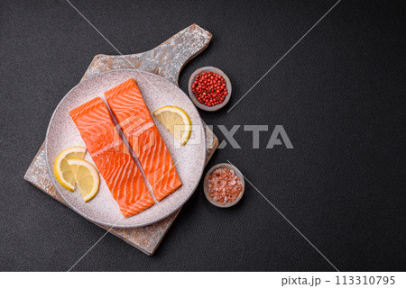 Fresh raw salmon steak with spices and herbs prepared for grilled baking 113310795