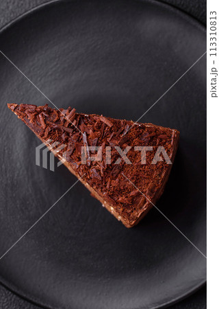 Delicious fresh cheesecake cake or snickers with cream and nuts on a ceramic plate 113310813