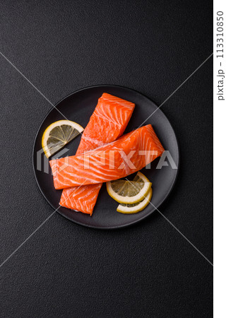 Fresh raw salmon steak with spices and herbs prepared for grilled baking 113310850