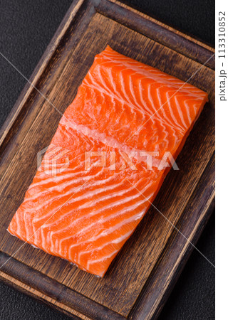 Fresh raw salmon steak with spices and herbs prepared for grilled baking 113310852