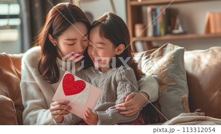 笑顔の母親と喜びに満ちた娘の間の優しい瞬間 笑顔の母親と喜びに満ちた娘の間の優しい瞬間 113312054