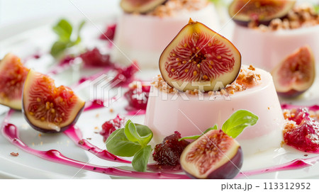 新鮮なイチジクのスライスで飾り、濃厚なベリーのクーリを添えたグルメなパンナコッタ デザート。 113312952