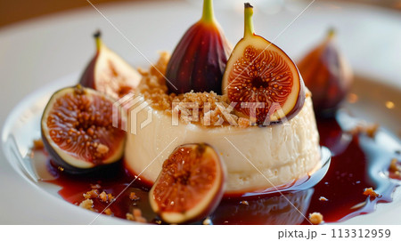新鮮なイチジクのスライスで飾り、濃厚なベリーのクーリを添えたグルメなパンナコッタ デザート。 113312959