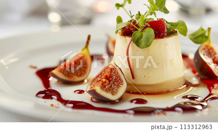 新鮮なイチジクのスライスで飾り、濃厚なベリーのクーリを添えたグルメなパンナコッタ デザート。 113312963