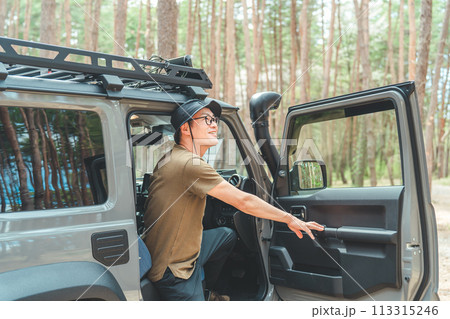 RV車・SUV・自動車で旅行・ドライブ・キャンプするアウトドア好きなキャンパーの男性 113315246