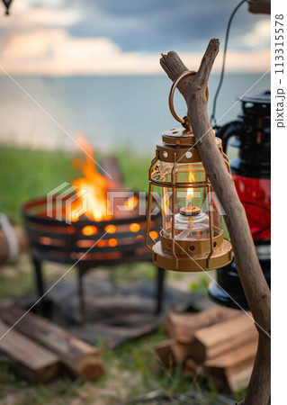 海 キャンプ 焚き火 炎 焚き火台 ランタン 灯り 夕方 海 キャンプ 焚き火 炎 焚き火台 ランタン 灯り 夕方 113315578