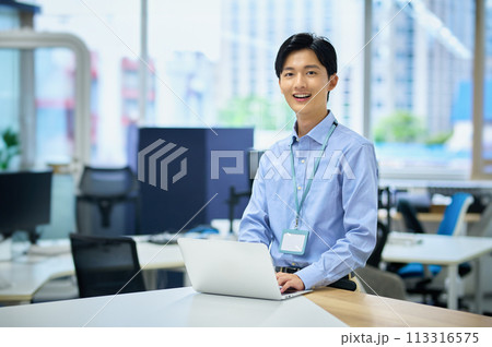 オフィスで働くパソコンを操作する私服の若い男性ビジネスマン オフィスで働くパソコンを操作する私服の若い男性ビジネスマン 113316575