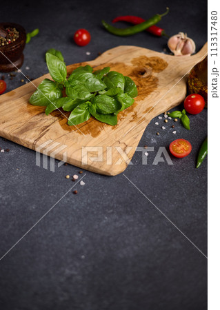 Green fresh Basil herb leaves on wooden cutting board Green fresh Basil herb leaves on wooden cutting board 113317480