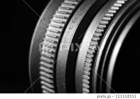 The image is a black and white close-up of a camera lens. The image is a black and white close-up of a camera lens. 113318551