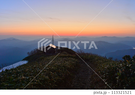 早春の越後駒ケ岳駒の小屋の夜明け、山頂より望む 113321521