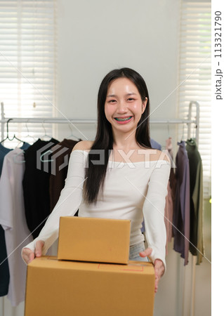 Asian business woman working at home preparing SME package boxes for delivery at small business home office. Asian business woman working at home preparing SME package boxes for delivery at small business home office. 113321790