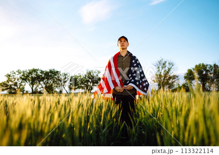 Man hold waving american USA flag. Patriot raise national american flag. Independence Day, 4th July. 113322114