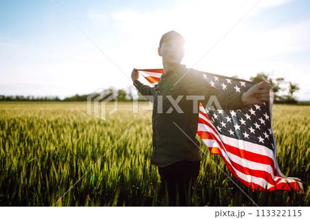 Man hold waving american USA flag. Patriot raise national american flag. Independence Day, 4th July. Man hold waving american USA flag. Patriot raise national american flag. Independence Day, 4th July. 113322115