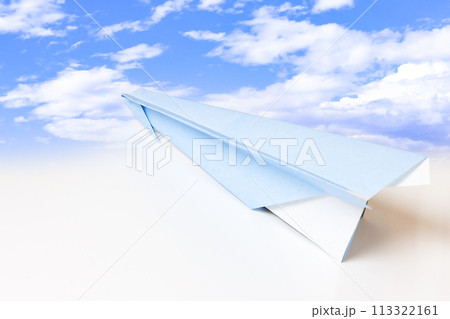 青空の背景を飛ぶ紙飛行機 113322161