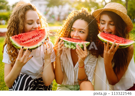 Three young woman have fun together and eating watermelon in hot summer day. Three young woman have fun together and eating watermelon in hot summer day. 113322546