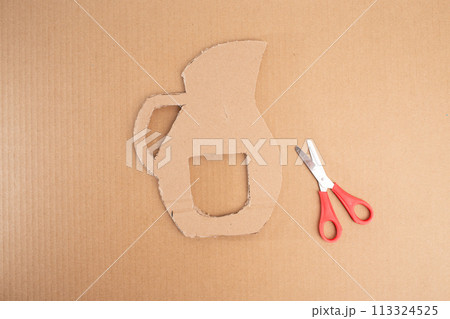 a paper cut out of a pitcher next to a pair of scissors, cut out of cardboard, assemble, 113324525