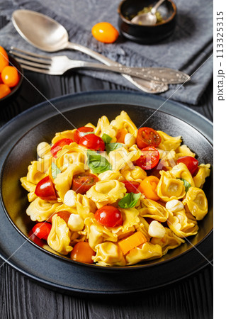 tortellini salad with tomatoes, mozzarella in bowl 113325315
