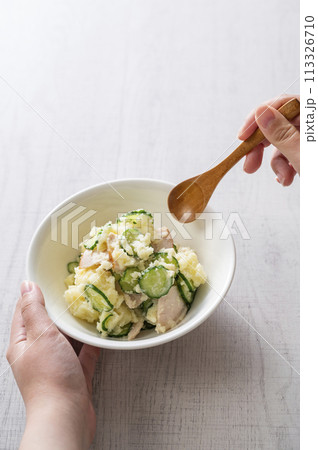 ポテトサラダを食べる女性の手 113326710