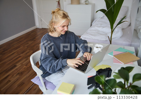Portrait of young woman distance learning, working from home with laptop, making notes, student studying on remote, doing online course Portrait of young woman distance learning, working from home with laptop, making notes, student studying on remote, doing online course 113330428