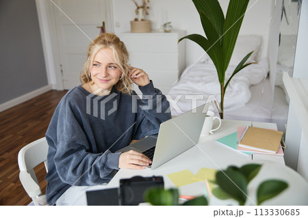 Portrait of woman sitting at desk with laptop, recording video of herself on laptop, making lifestyle video for social media account Portrait of woman sitting at desk with laptop, recording video of herself on laptop, making lifestyle video for social media account 113330685