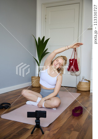 Young athletic woman trainer practicing Hatha Yoga, instructor personal training Vasisthasana, balancing pose, workout at home. Concept of healthy lifestyle and wellbeing 113330727