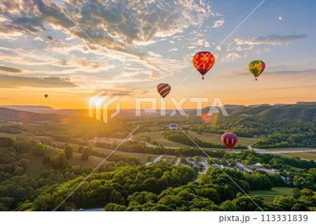 Top view of green landscape and mountain valleys and town and colorful balloons flying in the sky Top view of green landscape and mountain valleys and town and colorful balloons flying in the sky 113331839