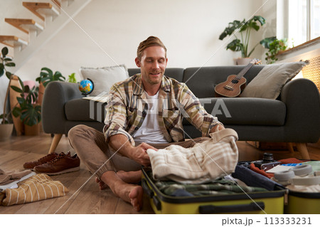 Portrait of man with suitcase, thinking what to bring on holiday, preparing for vacation, packing luggage Portrait of man with suitcase, thinking what to bring on holiday, preparing for vacation, packing luggage 113333231