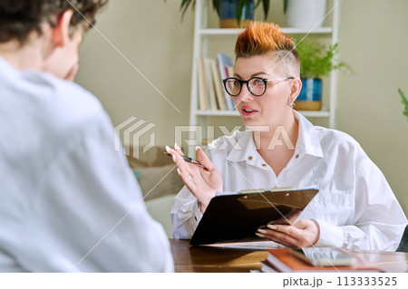 Female psychologist mental therapist working with young guy in office Female psychologist mental therapist working with young guy in office 113333525