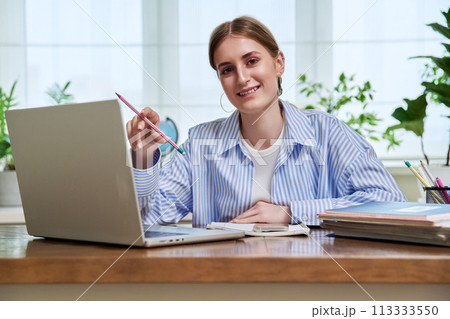 High school, college student smiling young female sitting at desk with computer High school, college student smiling young female sitting at desk with computer 113333550