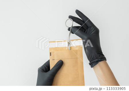 Woman manicure master or nail care beautician holding a manicure scissors on white wall. Cuticle scissors. Manicure scissors. Nail cutter. Woman manicure master or nail care beautician holding a manicure scissors on white wall. Cuticle scissors. Manicure scissors. Nail cutter. 113333905