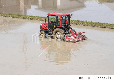 トラクターで代かきをする風景 水田とトラクター 田植えの準備作業 農作業イメージ イメージ素材 トラクターで代かきをする風景 水田とトラクター 田植えの準備作業 農作業イメージ イメージ素材 113333914