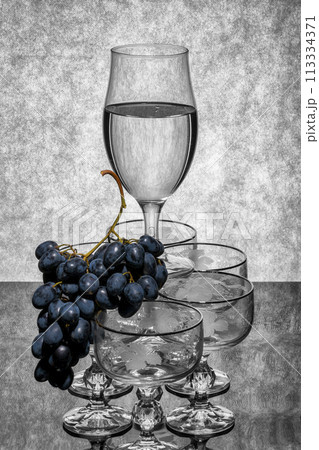 Still life with glassware and a bunch of grapes Still life with glassware and a bunch of grapes 113334371