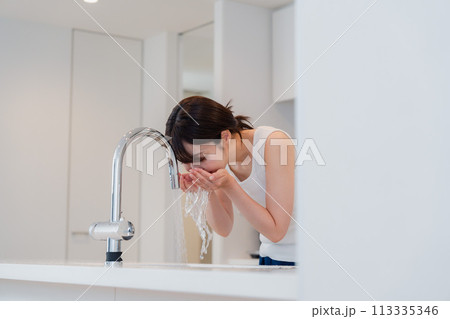 家で洗顔をする若い女性 113335346