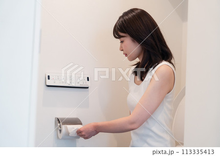 トイレットペーパーを引っ張る若い女性 113335413