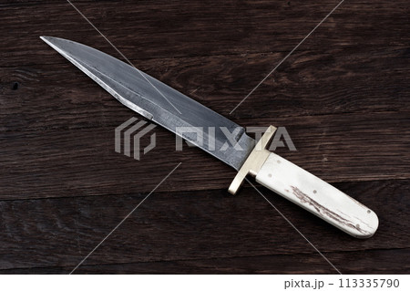 Old west bowie knife on wooden deck Old west bowie knife on wooden deck 113335790