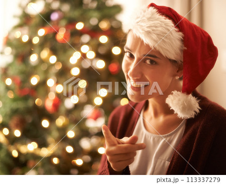 Christmas, portrait or woman for finger, warning or naughty in playful break in festive season. Gen z female person, red hat or smile to hey you, no or humor to relax in living room, tree and lights 113337279
