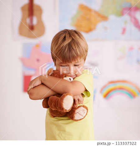 Child, boy and hug teddy bear, toys for safety and security in childhood with comfort and care in playroom. Peace, calm and affection with stuffed animal, soft and fluffy for love and youth at home Child, boy and hug teddy bear, toys for safety and security in childhood with comfort and care in playroom. Peace, calm and affection with stuffed animal, soft and fluffy for love and youth at home 113337322