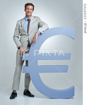 Portrait, Euro currency symbol and man with business, finance and investor on a grey studio background. Person, employee and model with accountant, trader and stock market with economy, emoji or icon Portrait, Euro currency symbol and man with business, finance and investor on a grey studio background. Person, employee and model with accountant, trader and stock market with economy, emoji or icon 113337372