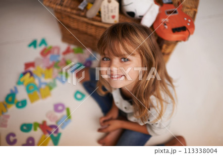 Girl, child and smile with letter toys for learning, development and games in playroom at home. Portrait, education and growth in childhood with alphabet, language and happy kid playing for fun 113338004