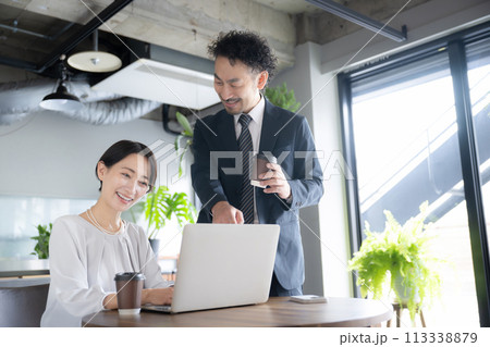 綺麗な会社(オフィス)で打合せをするミドルの男女 113338879