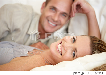Couple, smile and portrait in bed together, relax and support or hotel for bonding. Happy people, commitment and romance for date in bedroom, peace and affection for connection in relationship 113338941