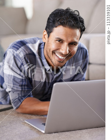 Man, freelancer and internet for laptop in portrait of living room, research and scroll or browse on website. Happy male person, floor and online for information or home for app, remote work and plan 113339101