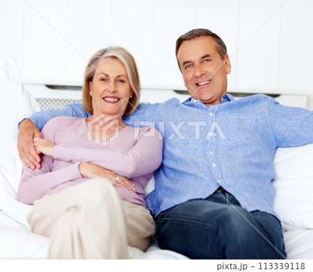 Senior, couple and portrait or happy on sofa with support, relationship and marriage in retirement home. Elderly, man and woman with smile on couch in living room with trust, care and love in house 113339118