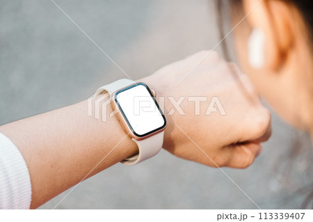 Close-up of a person wrist wearing a modern smartwatch with a blank screen, indicating connectivity and technology in everyday life. Close-up of a person wrist wearing a modern smartwatch with a blank screen, indicating connectivity and technology in everyday life. 113339407