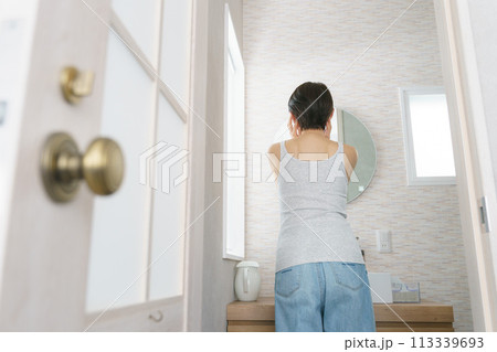 洗面所で朝の支度をする女性の後ろ姿 113339693