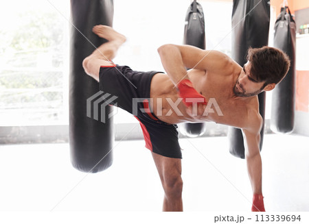 Man, boxing and bag kick as training exercise or cardio challenge or fitness practice, class or combat. Athlete, professional and gloves or workout performance in America or gym, strength or sport 113339694