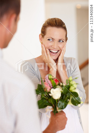 Wow, happy and woman with flowers for wedding, marriage and love with man for bonding in background. Female person, girl and wife with husband for bouquet, union and partnership of couple together 113340084