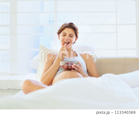 Breakfast in bed, eating and pregnant woman with strawberry bowl in a house, happy or hungry. Fruit, smile and female person in bedroom with pregnancy nutrition for health, balance or wellness Breakfast in bed, eating and pregnant woman with strawberry bowl in a house, happy or hungry. Fruit, smile and female person in bedroom with pregnancy nutrition for health, balance or wellness 113340369
